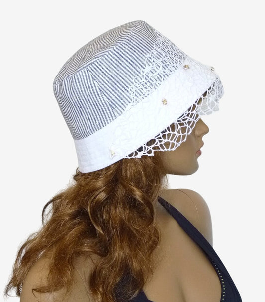 Side view of gray and white striped bucket hat with delicate veil and seashells