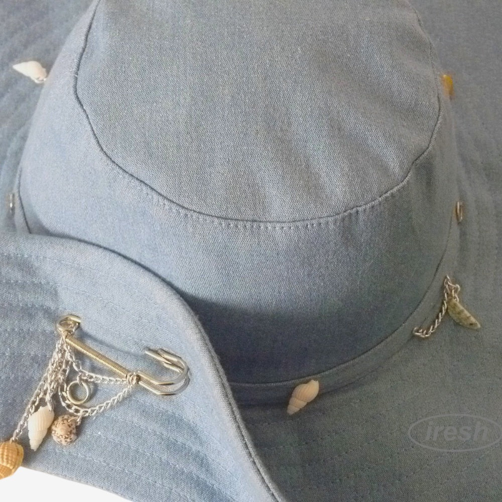 Close-up of hat brim lifted and secured with decorative brooch