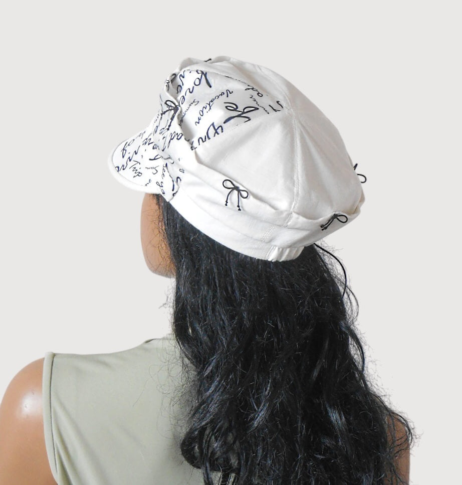 White linen cap with black bows, lightweight summer headwear, back view  