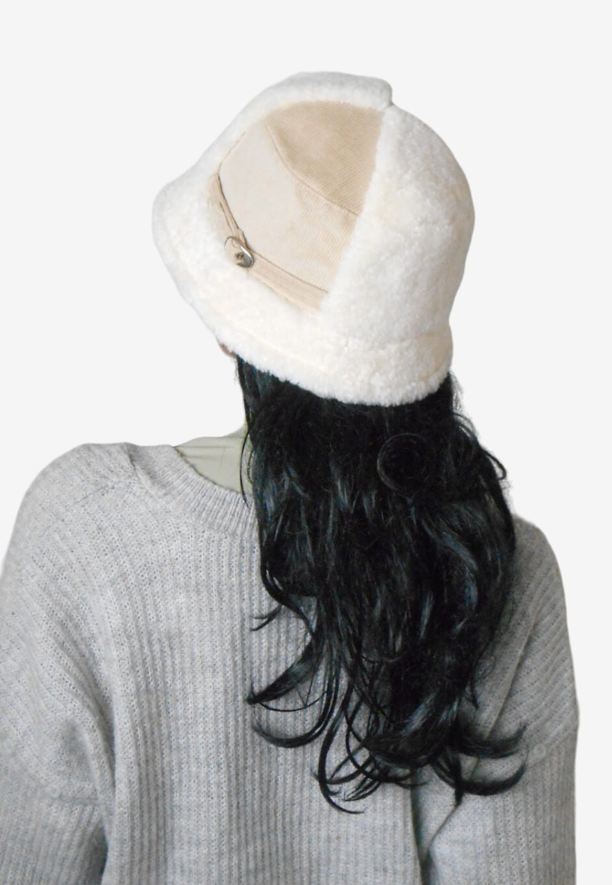 Back view of a beige corduroy bucket hat with white faux fur
