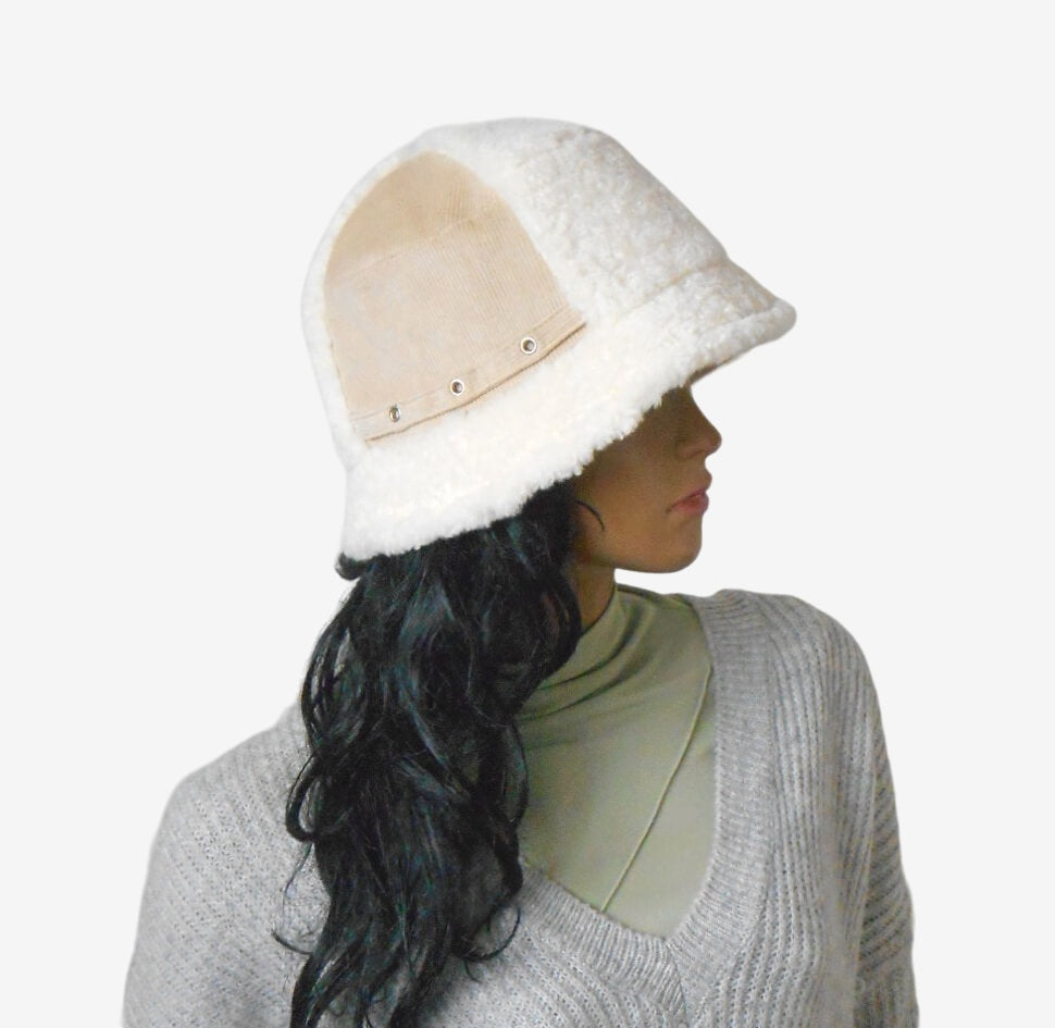 Side view of beige corduroy bucket hat with white faux fur