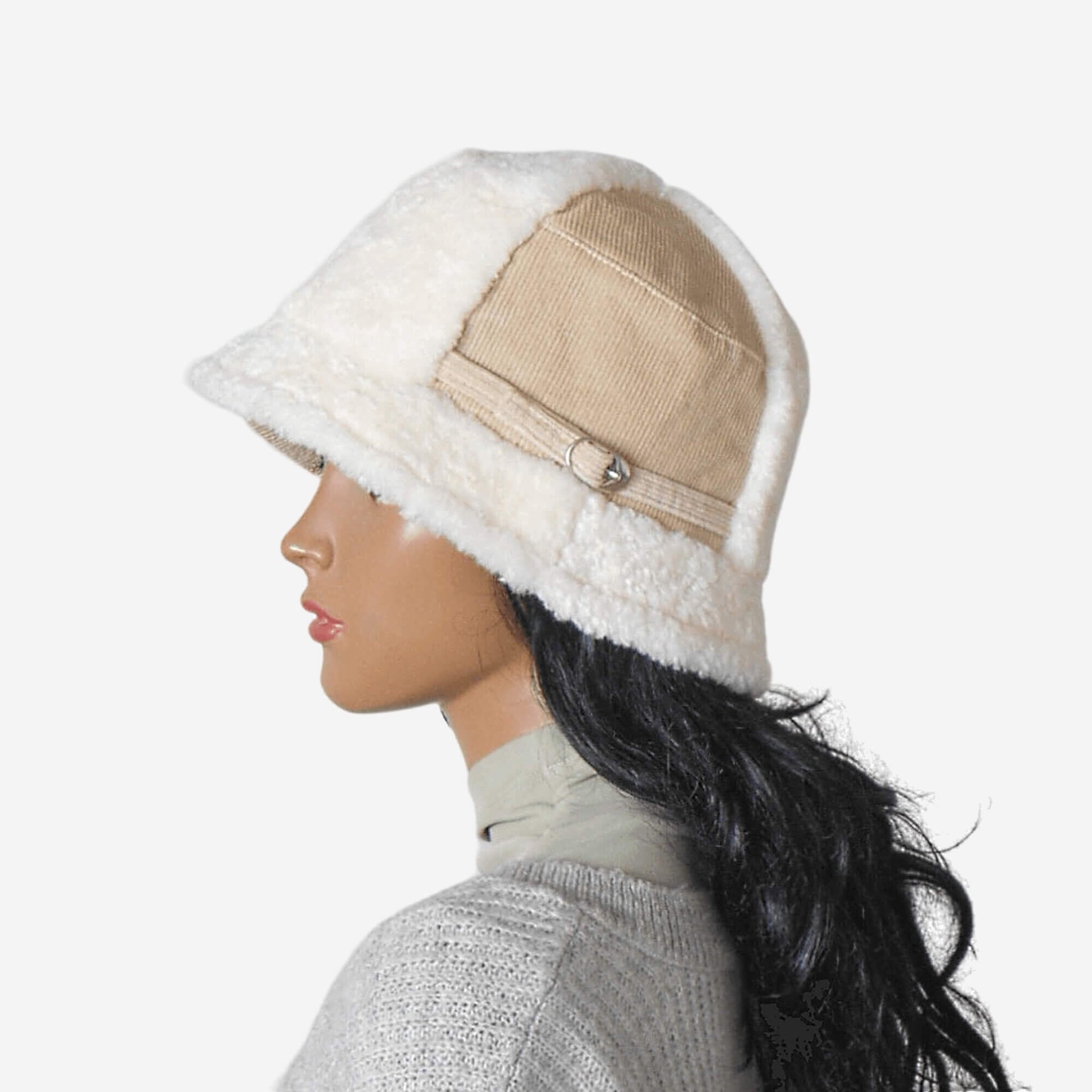 A beige winter bucket hat with faux fur and a buckle strap on the side

