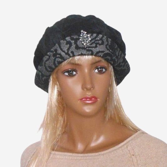 A mannequin head wearing a black velvet beret hat with a small brim and a brooch on the front.