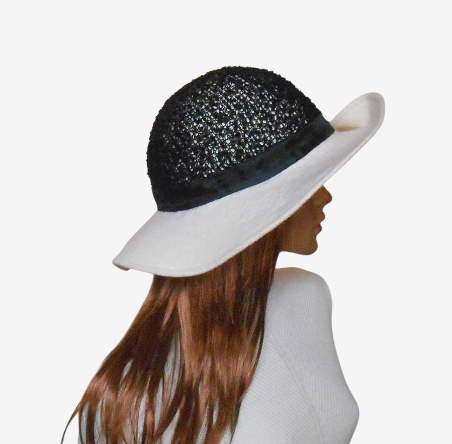 Side view of black and white felted wide-brim hat showing brim and shape