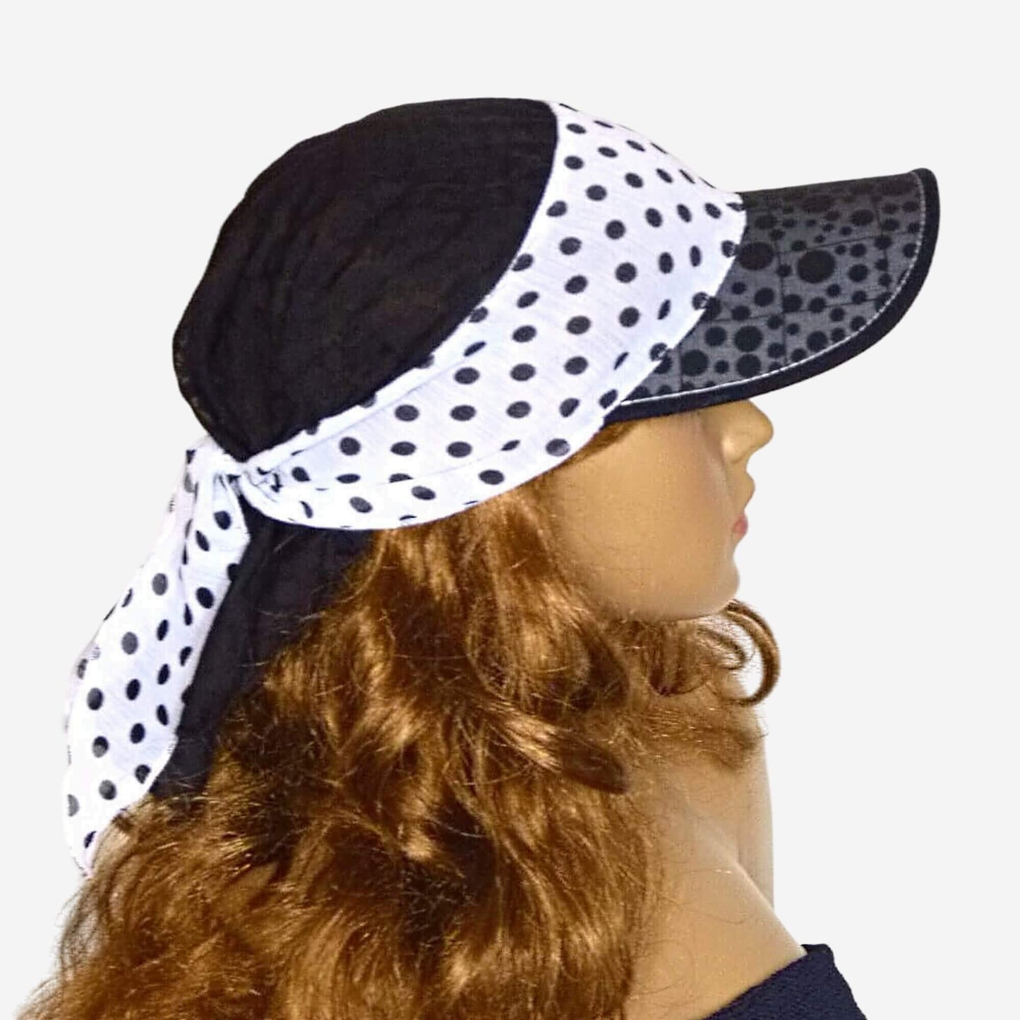 A woman wearing a black and white polka dot bandana visor hat.
