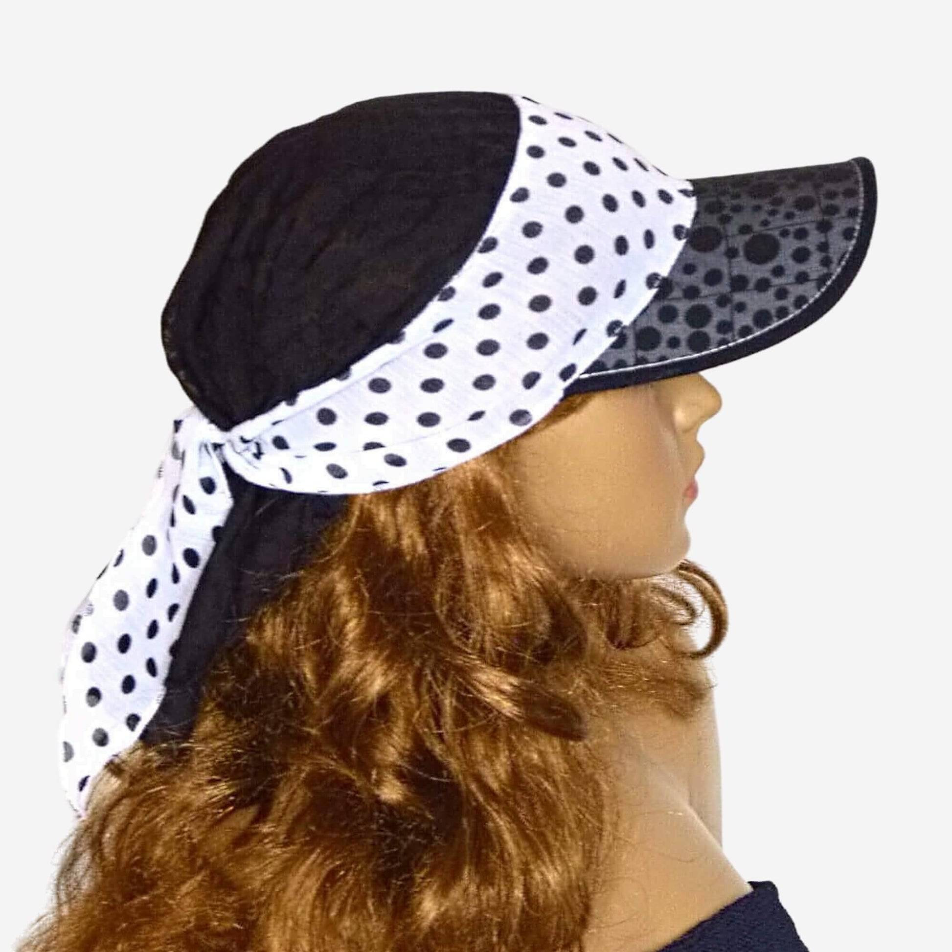 A woman wearing a black and white polka dot bandana visor hat.