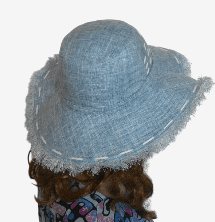 Back view of blue wide-brimmed linen hat with fringe-edged brim, deep side crease, and soft cotton lining