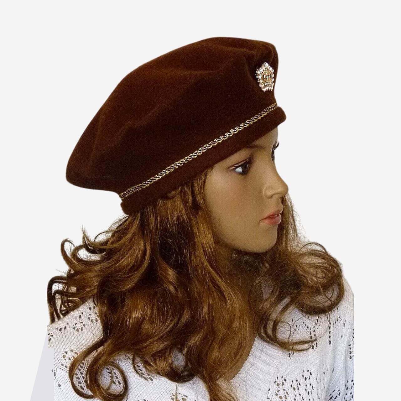 Three-quarter view of brown merino wool beret styled with brooch and braid