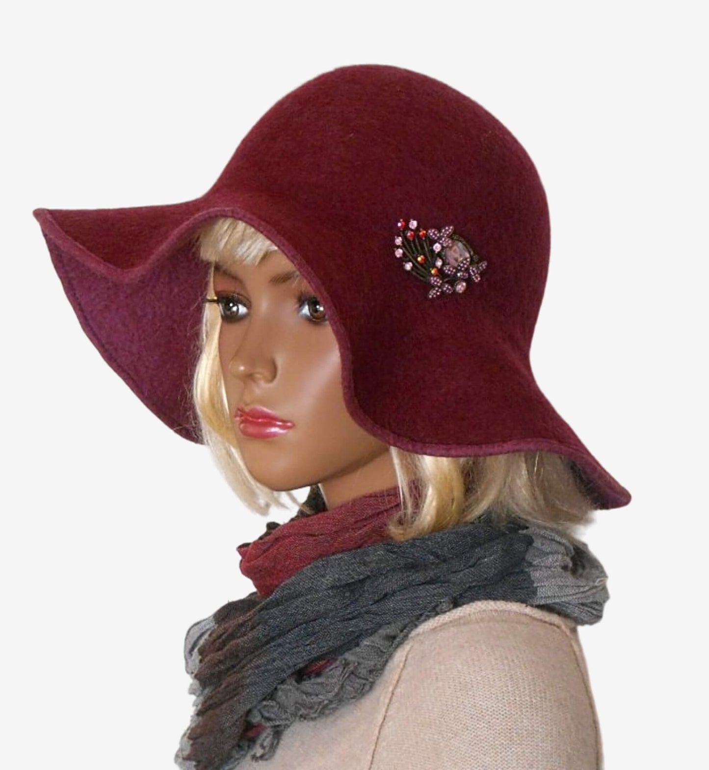 Burgundy felt hat with decorative brooch on the brim, side view