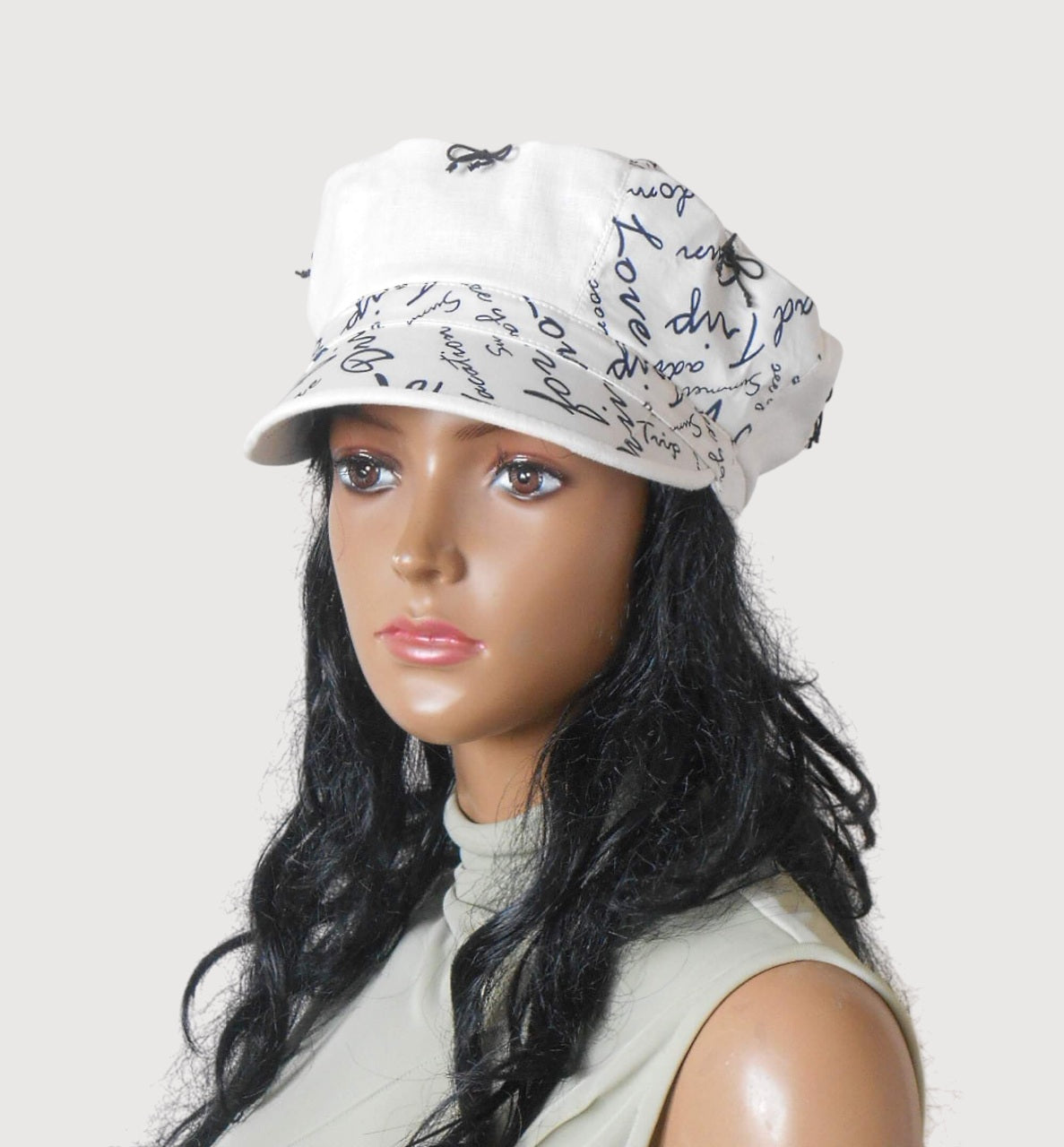 Front view of white linen cap with tiny black bows, cotton lining, summer headwear for women  