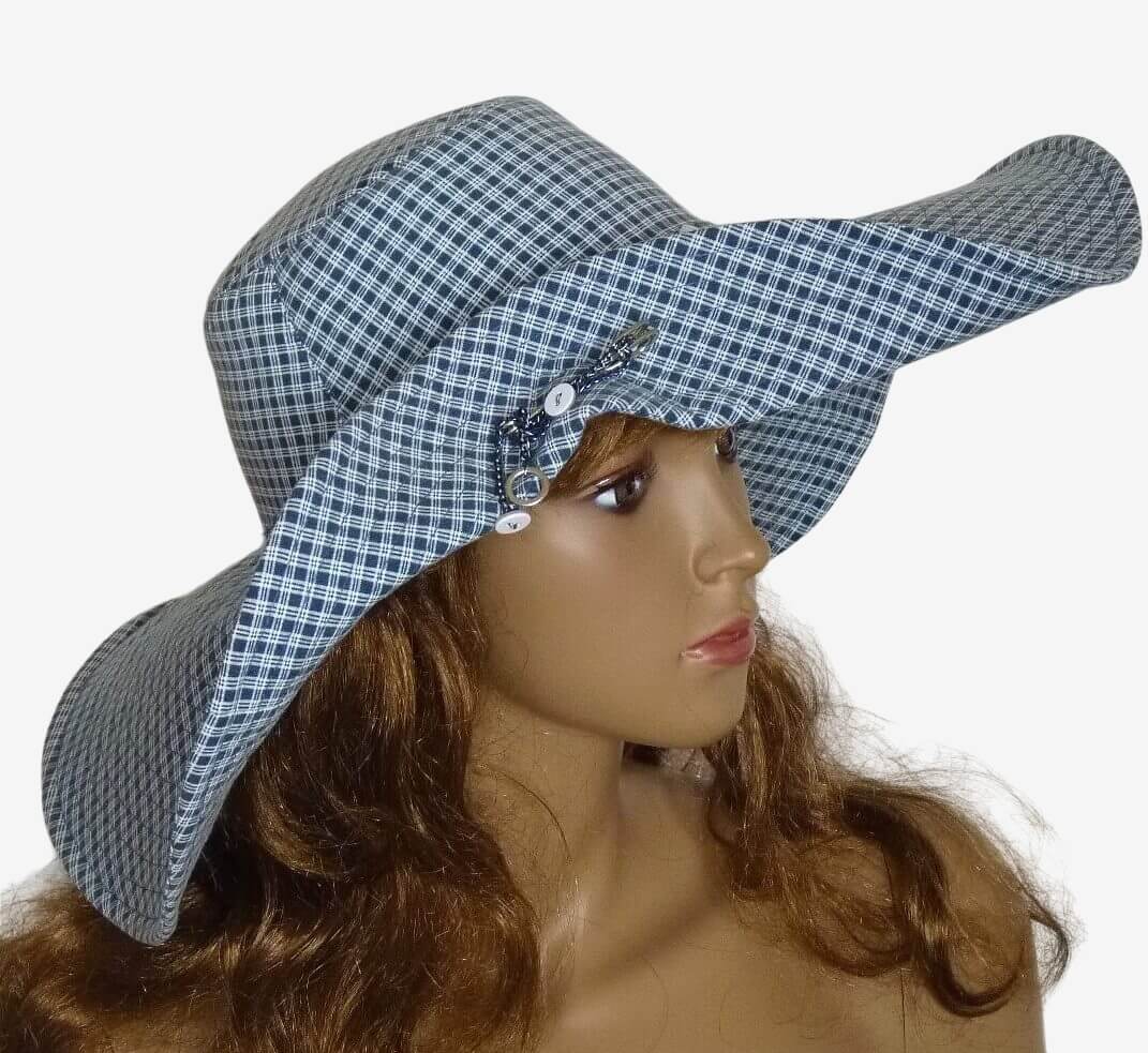 Blue and white checkered sun hat with raised brim secured by decorative brooch