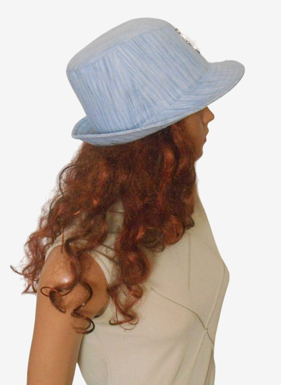Side view of blue denim trilby hat showing brim and crown shape