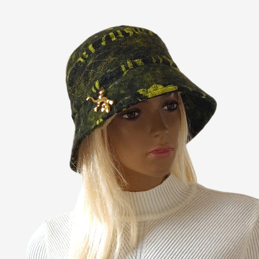 A fashionable wool felted bucket hat in dark green, black, and light green, decorated with a brooch