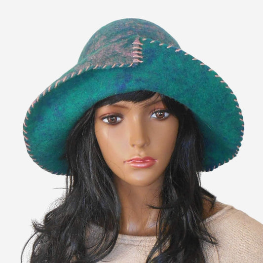 A green felt floppy hat with a soft brim displayed on a mannequin head.
