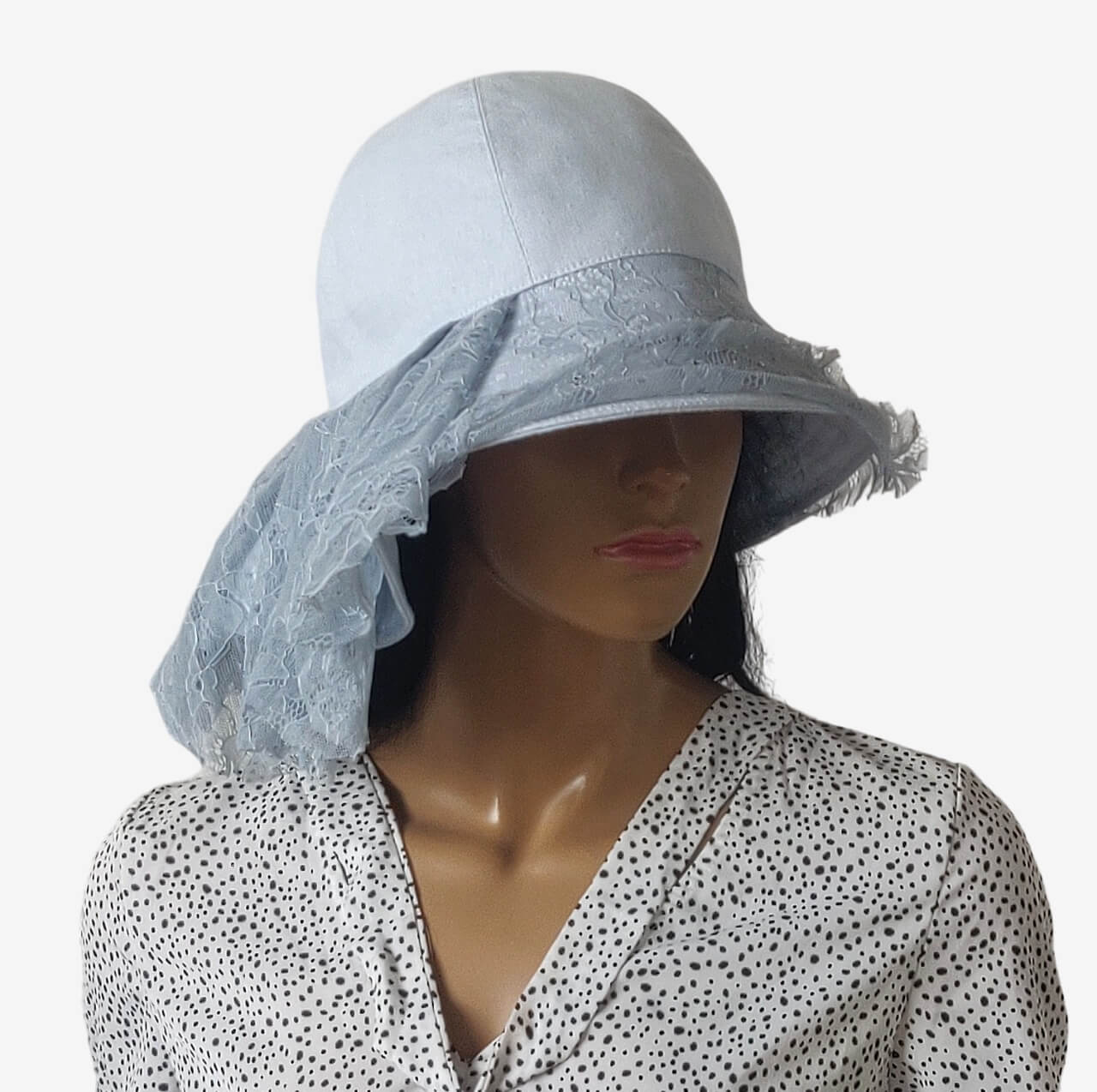 Romantic style light blue linen summer hat with asymmetrical brim and delicate lace drapery.