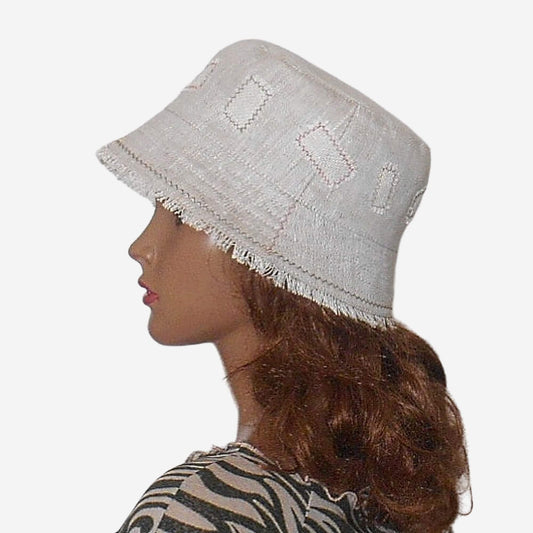Side view of eco-friendly linen bucket hat showing fringe detail, lightweight summer hat in beige