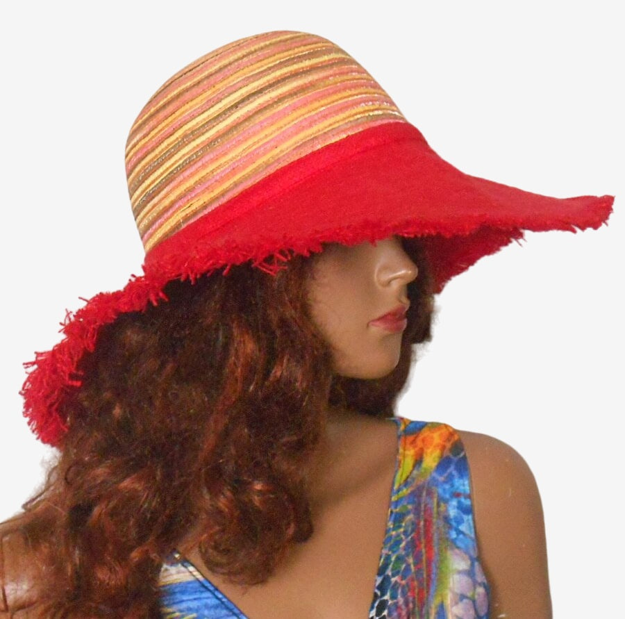 Three-quarter view of vibrant red linen hat with wide fringed brim and multicolored crown, lightweight and breathable summer hat
