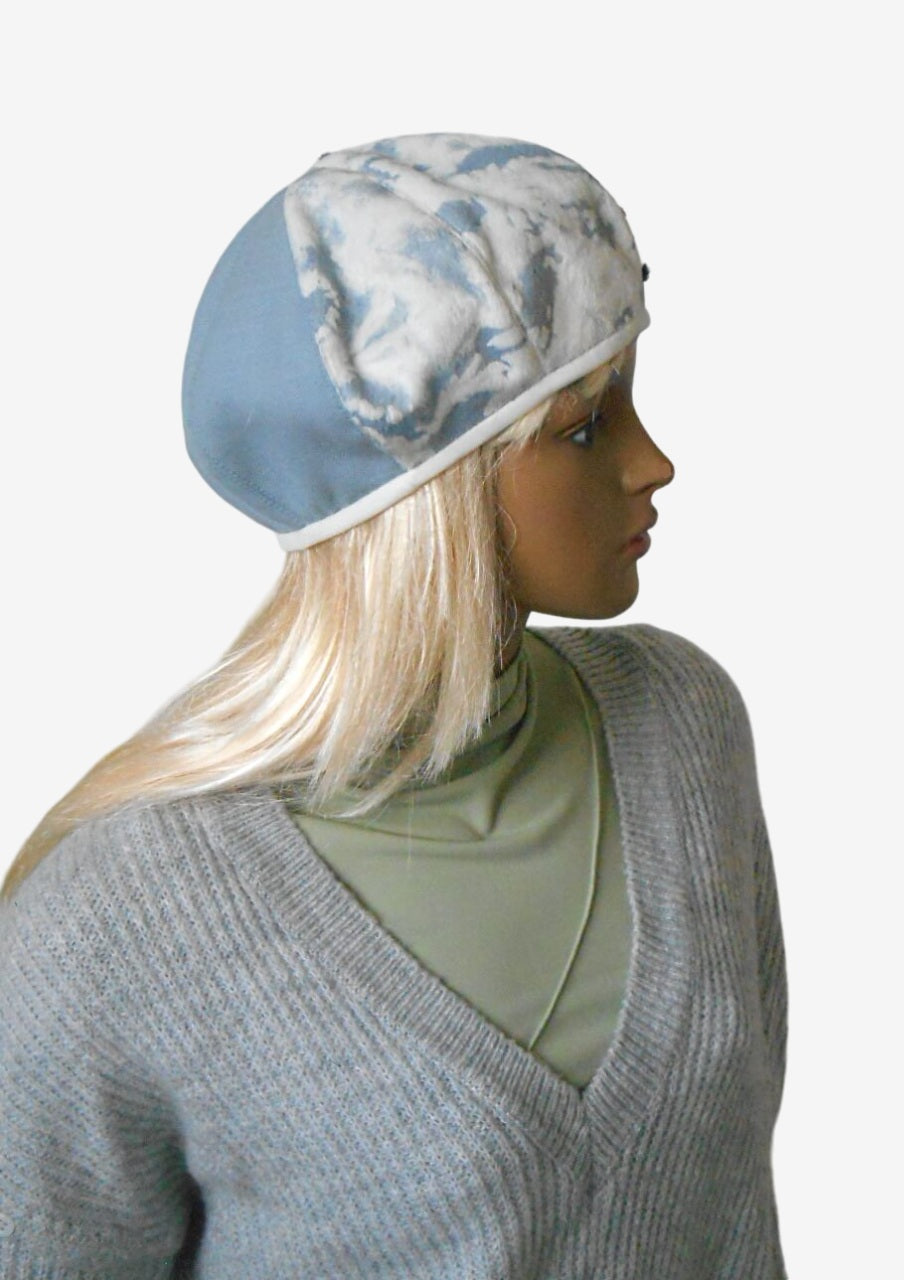 Women’s blue and white beret showing decorative braid, side view  