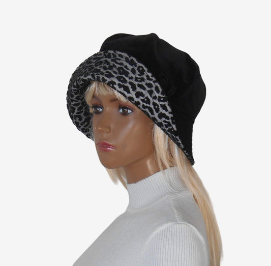 Three-quarter view of black velour beret with leopard print and brim