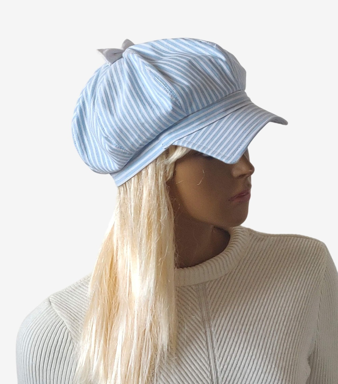 Three-quarter view of women’s blue and white striped newsboy cap with white bow