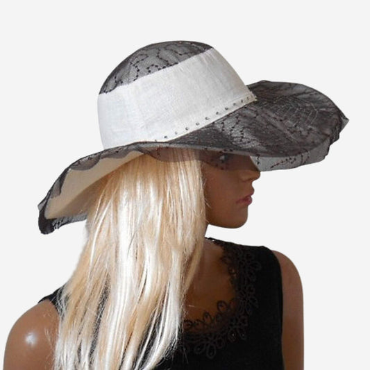 A mannequin head wearing a white wide-brimmed hat with a brown lace veil.