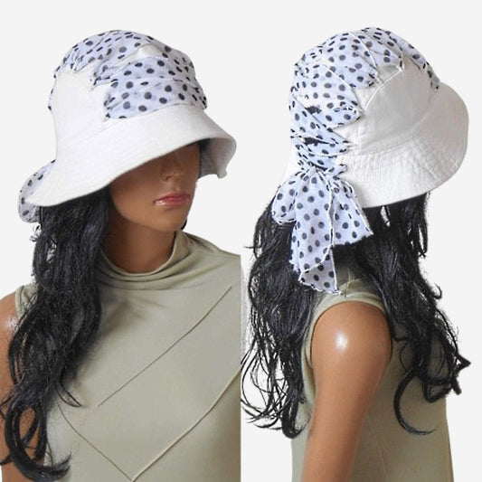 A white cotton hat with black polka dots, displayed on a mannequin head, showing the front and side views.