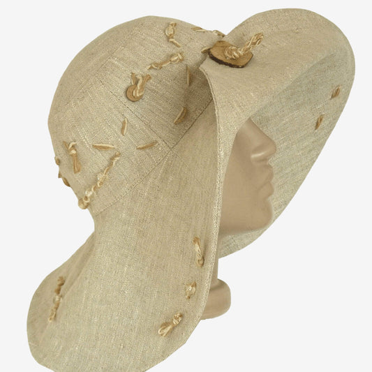 A beige wide-brimmed linen hat with decorative elements on the brim, displayed on a mannequin head.