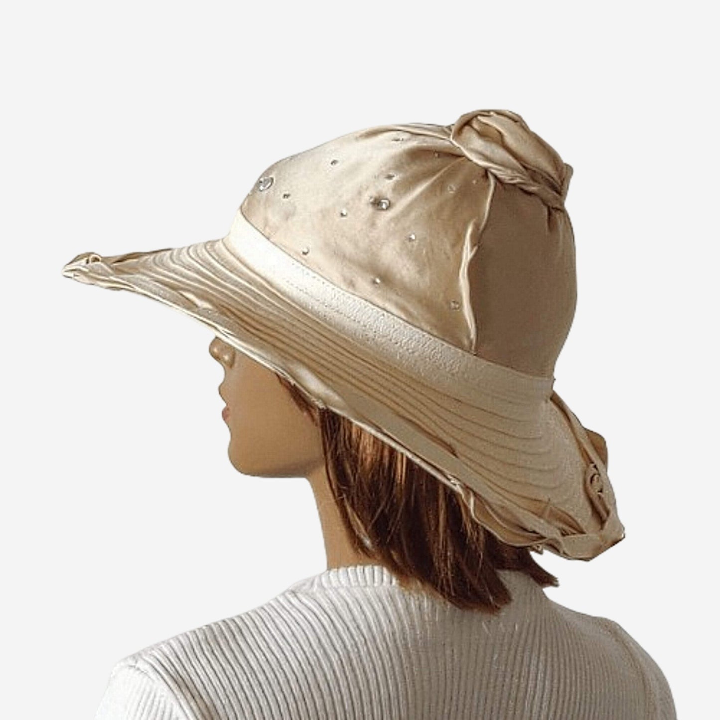 A wide-brimmed beige hat with a natural silk top, decorated with rhinestones