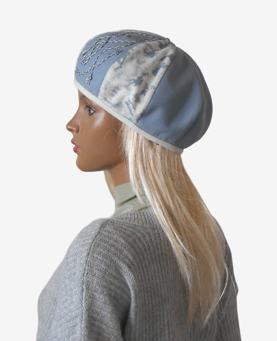 Side view of women’s blue and white beret showing decorative braid