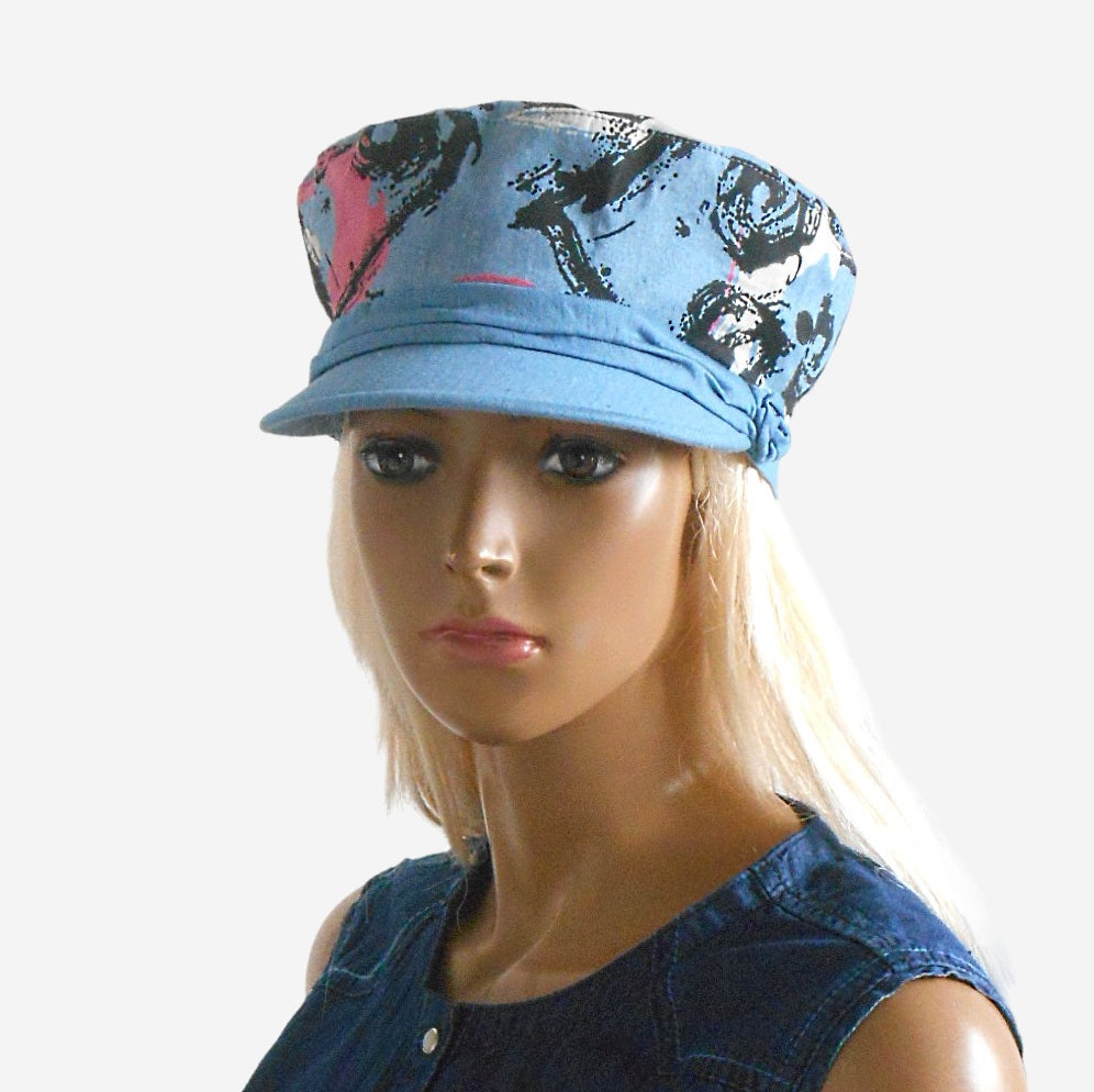 Front view of women’s summer denim captain’s cap with abstract pattern and draped detail