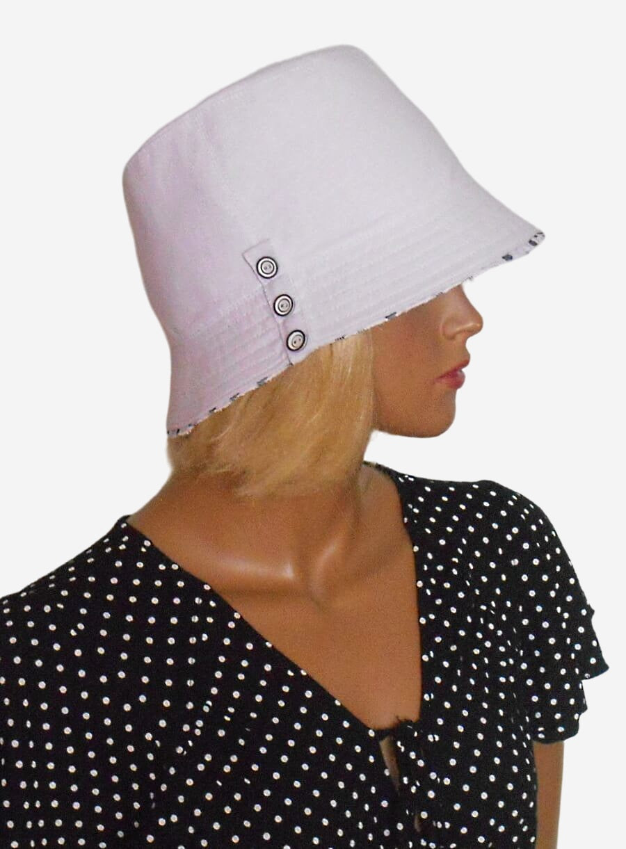 Side view of white linen summer hat with asymmetrical brim